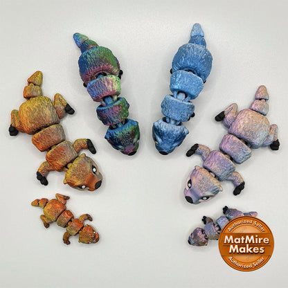 A selection of medium and micro-sized 3D printed Otter pups, designed as flexible fidget toys.
