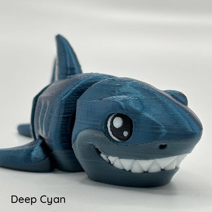 3D printed using a silky dark blue pla filament, this great white shark has a segmented body and rotating fins.
