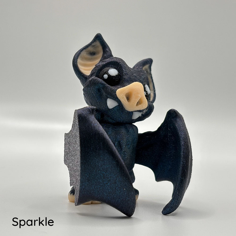 Made with a sparkling blue-black PLA filament, this 3D printed vampire bat has movable wings and head.