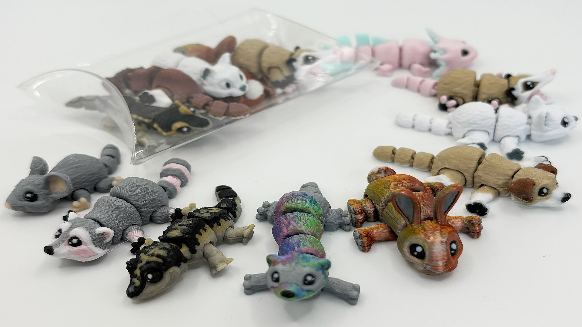 A selection of 3D printed flexible fidget toys with articulated joints, suitable for small world play - themes include pets, reptiles, aquatic animals and wildlife